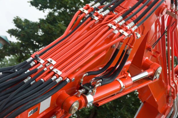 Hydraulic hoses intricately connected to a machinery unit